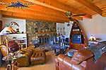 Casual mountain decor with comfortable leather sofa and wood burning stone fireplace