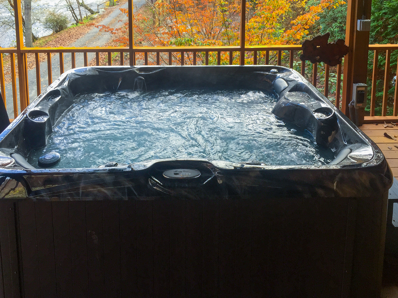 A river paradise hot tub on coverd deck overlooking tucasegee river